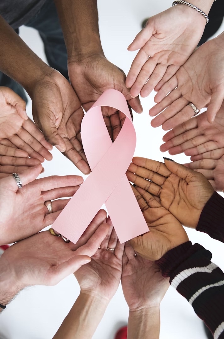 Hands holding a pink ribbon